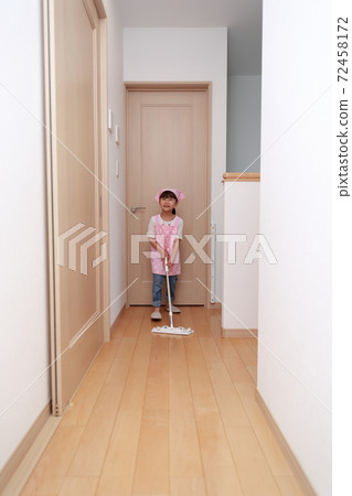 A 5-year-old girl helping with cleaning with a quick wiper 72458172