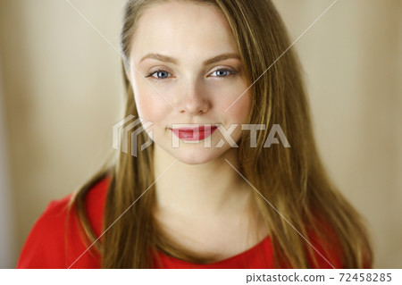 Head shot of a smart confident smiling millennial european woman standing with folded arms at home. Attractive young teenager student girl freelancer looking at camera, dressed in red 72458285