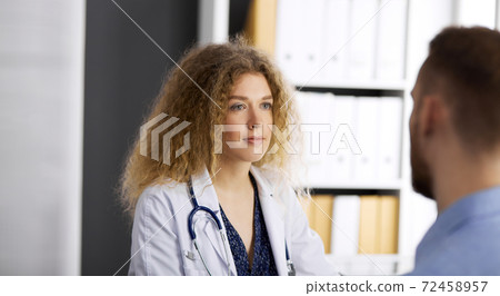 Female doctor and male patient discussing current health examination while sitting in clinic. Perfect medical service and medicine concept 72458957