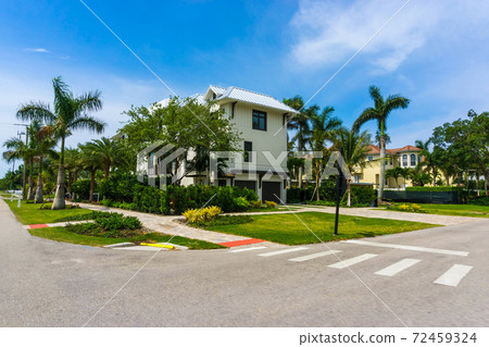 Typical Florida home in the countryside with palm trees, tropical plants and flowers Typical Florida home in the countryside with palm trees, tropical plants and flowers 72459324