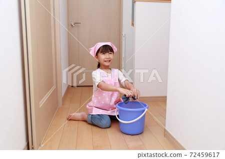 一個5歲女孩用抹布幫助擦地板 72459617
