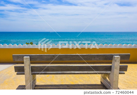 Empty bench on a wooden deck at the shore of beautiful blue sea Empty bench on a wooden deck at the shore of beautiful blue sea 72460044