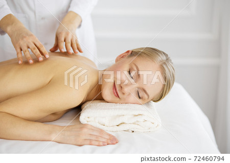 Caucasian woman getting a back massage in the spa salon Stock