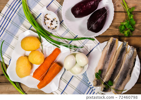 Ingridients for russian salad. Potatoes, carrots, herring, eggs placed on the table. Ready for cooking. 72460798