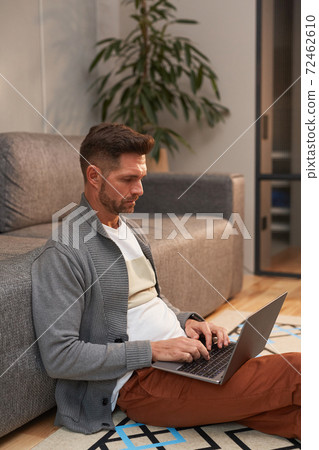 Contemporary Man Working with Laptop on Floor 72462610