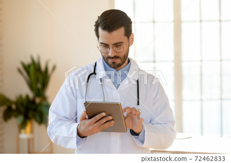 Male doctor use tablet consulting patient online Male doctor use tablet consulting patient online 72462833