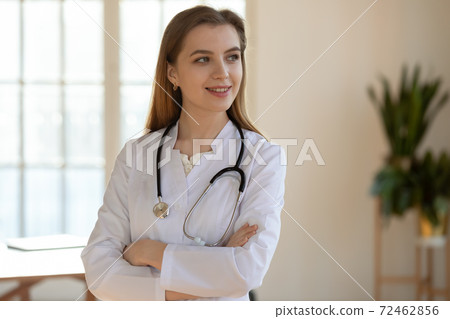 Smiling female doctor look in distance thinking Smiling female doctor look in distance thinking 72462856