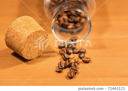 Roasted coffee beans on table with jar Roasted coffee beans on table with jar 72463123