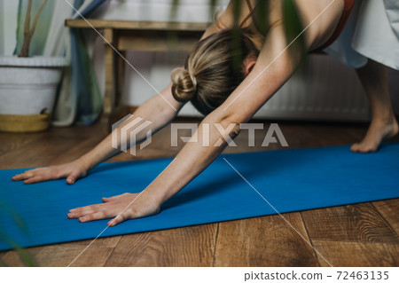 Home Fitness, workout in new normal, pandemic lockdown time, Yoga at home. Young woman working out, practice yoga in living room. Home Fitness, workout in new normal, pandemic lockdown time, Yoga at home. Young woman working out, practice yoga in living room. 72463135