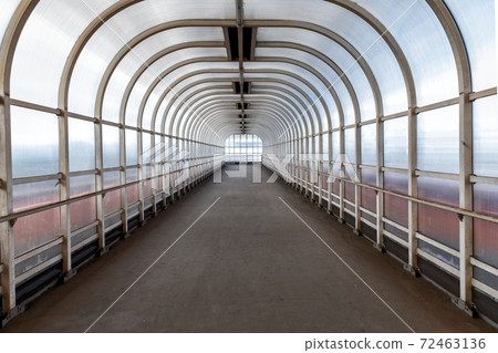 Pedestrian passage with glass walls angle shot Pedestrian passage with glass walls angle shot 72463136