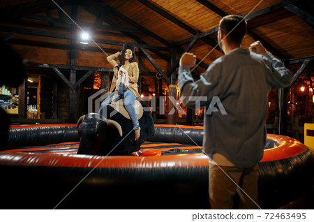 Love couple on rodeo attraction in amusement park Love couple on rodeo attraction in amusement park 72463495