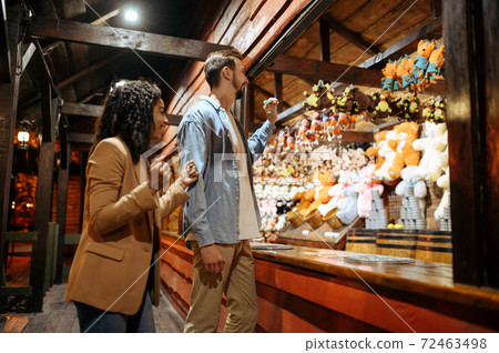 Love couple playing darts in amusement park Love couple playing darts in amusement park 72463498