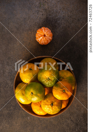 Tangerines or mandarines in bamboo bowl on wooden background Tangerines or mandarines in bamboo bowl on wooden background 72463726