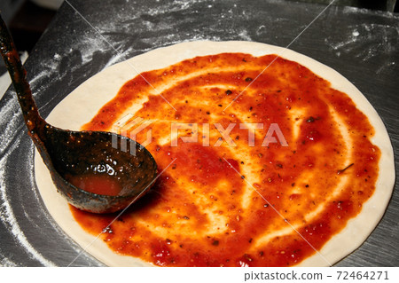 Adding tomato sauce while preparation of Italian pizza. Adding tomato sauce while preparation of Italian pizza. 72464271