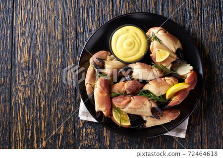 crab claws with mustard sauce , lemon and rosemary on a wooden table, top view. crab claws with mustard sauce , lemon and rosemary on a wooden table, top view. 72464618