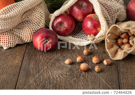 Hazelnuts in a linen sac, apples and vegetables in an ecological mesh bag - zero waste concept Hazelnuts in a linen sac, apples and vegetables in an ecological mesh bag - zero waste concept 72464826