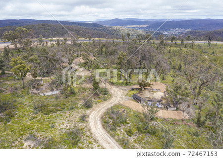 Aerial photograph of a dirt track and a forest after bushfires in regional Australia 72467153