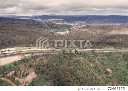 Aerial photograph of a highway and a forest after bushfires in regional Australia 72467155