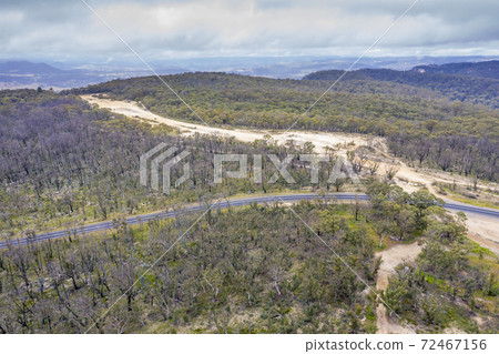 Aerial photograph of a highway and a forest after bushfires in regional Australia 72467156