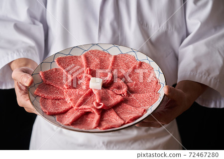 Itamae holding a beef shoulder loin slice in hand 72467280