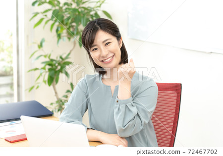 A woman who poses a gut in front of a personal computer A woman who poses a gut in front of a personal computer 72467702