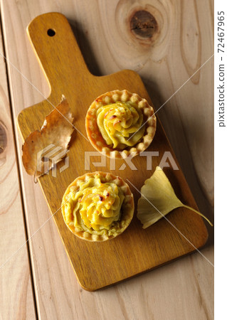 Sweet potatoes and ginkgo leaves on the cutting board (overhead view) 72467965