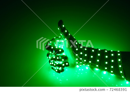 thumbs up hand covered with green led lights, illuminated background thumbs up hand covered with green led lights, illuminated background 72468391