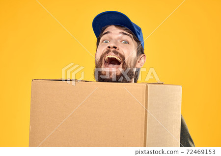 A man in a working form a box with loading tools yellow background A man in a working form a box with loading tools yellow background 72469153