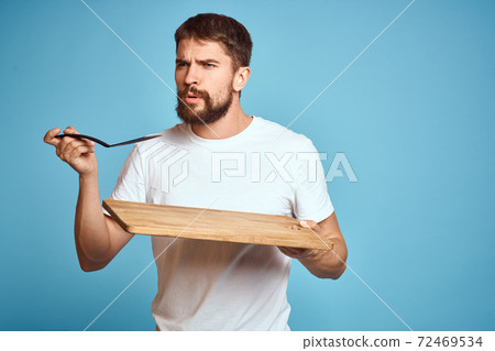 cute man with kitchen board near face on blue background emotions smile model cute man with kitchen board near face on blue background emotions smile model 72469534