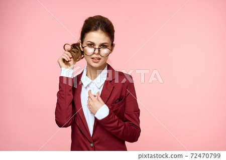 Business woman red jacket glasses executive lifestyle studio pink background Business woman red jacket glasses executive lifestyle studio pink background 72470799