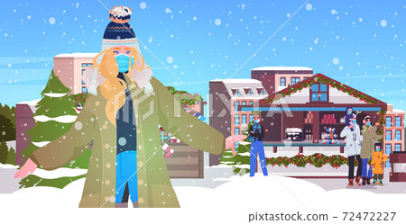 mix race people walking at christmas market men women wearing masks to prevent coronavirus pandemic 72472227