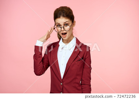 Business woman red jacket glasses executive lifestyle studio pink background Business woman red jacket glasses executive lifestyle studio pink background 72472236
