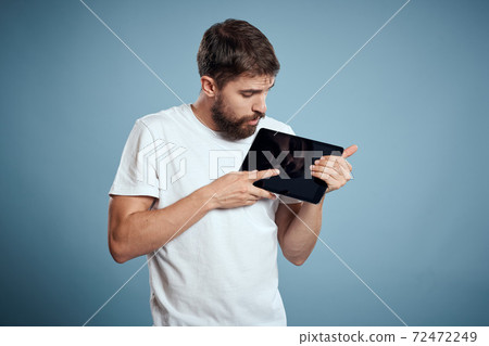 man with tablet near face on blue background cropped view touch monitor new technologies Copy Space 72472249