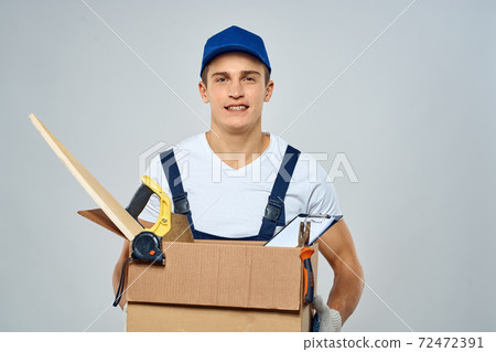 man in working uniform with a box in his hands tools loader delivery light background man in working uniform with a box in his hands tools loader delivery light background 72472391