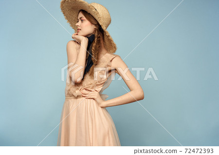 Girl in a pink dress on a blue background gestures with her hands romance model fun emotions cropped view 72472393