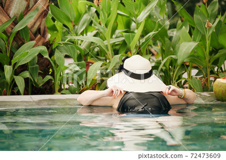 Woman resting in swimming pool 72473609