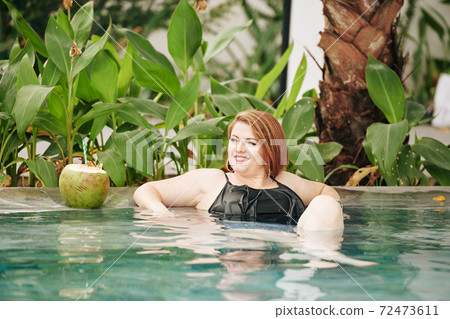 Woman relaxing in swimming pool 72473611