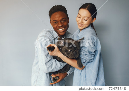 International couple on a blue background with a dog International couple on a blue background with a dog 72475848