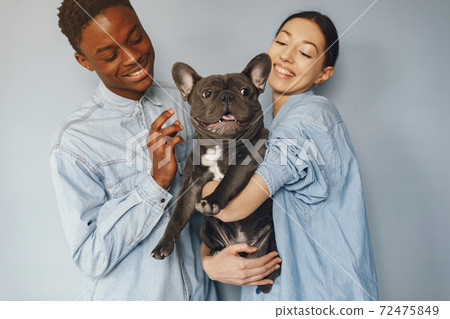 International couple on a blue background with a dog International couple on a blue background with a dog 72475849
