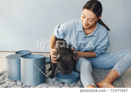 Elegant woman in a blue shirt with black bulldog Elegant woman in a blue shirt with black bulldog 72475867