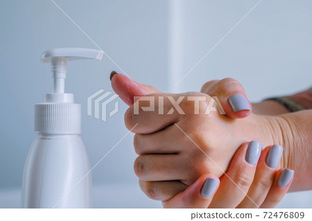 Woman cleaning and rubbing hands with antiseptic gel - close up side view Woman cleaning and rubbing hands with antiseptic gel - close up side view 72476809