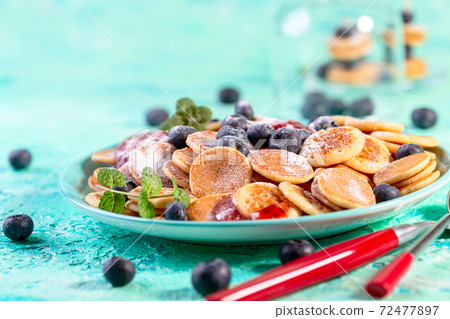 Tiny pancakes with fresh blueberries. 72477897