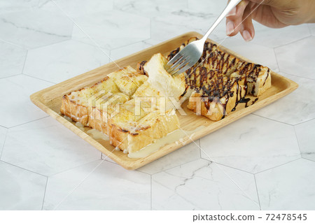 Toast with sweetened condensed milk and Chocolate syrup on wooden plate. Toast with sweetened condensed milk and Chocolate syrup on wooden plate. 72478545