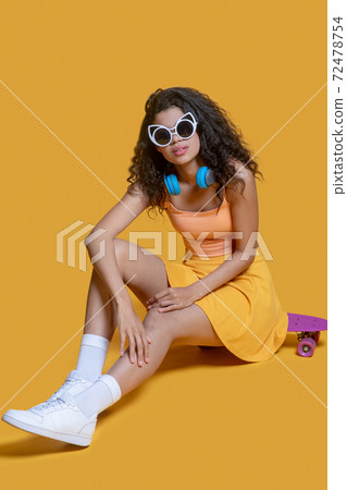 Pretty dark-haired young girl with a skateboard looking good 72478754