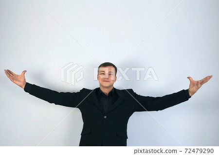 Showman magician presents his show, spreading his hands up to the sides. 72479290