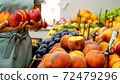 Young caucasian woman is choosing a nectarines at supermarket 72479296