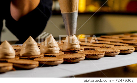 Chef is making caramel macarons, close-up. 72479302