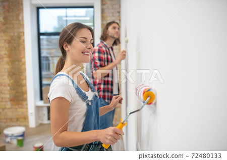Young couple painting wall in their new house 72480133