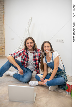 Young couple sitting on the floor and smiling 72480285