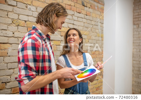 Young couple looking at color palette and choosing the wall color 72480316